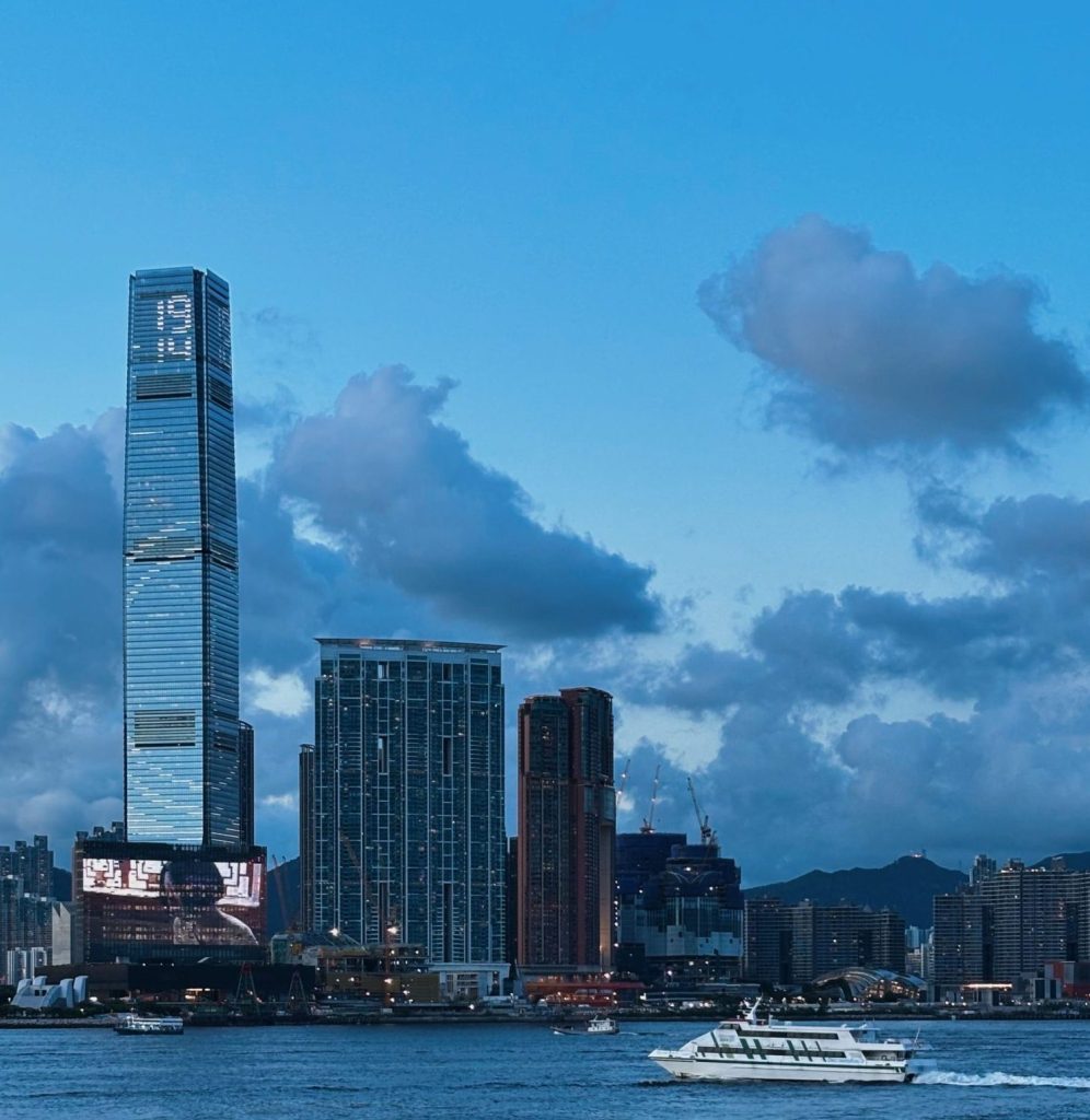 Skyline view of Hong Kong with boats on Victoria Harbour during the day.