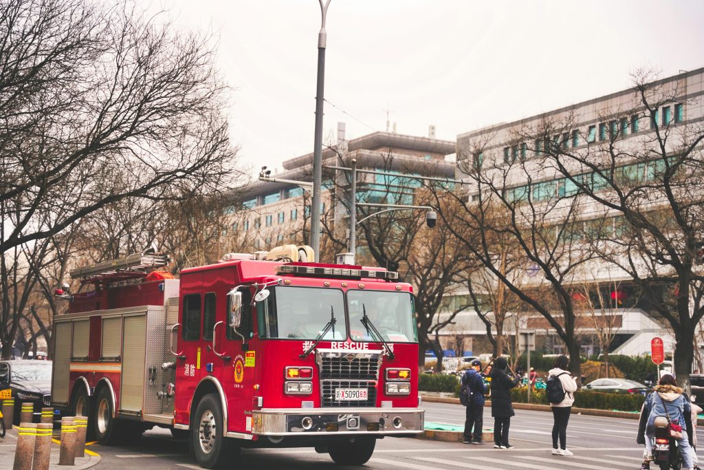 A vibrant red fire truck on duty in a bustling street in Beijing, China.