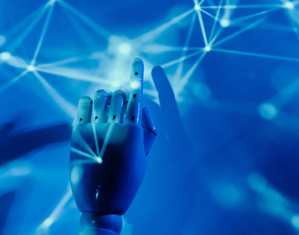 Futuristic robotic hand touching a digital network on a blue background.